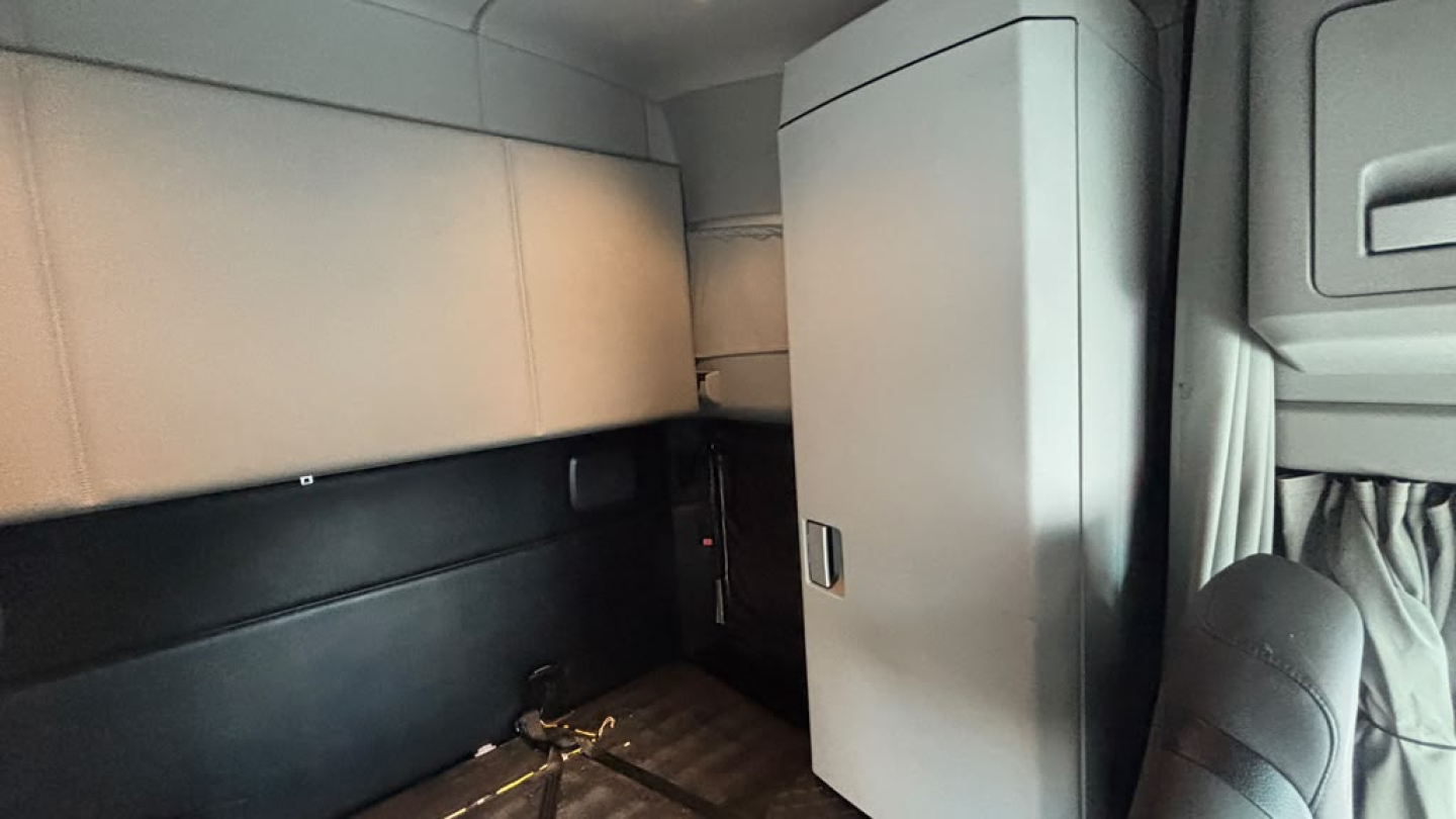 Kenworth T680 truck interior cab area with storage cabinet and sleeper dash.