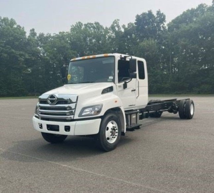 Hino L6 cab chassis truck front-left view showing white cab and chassis with two-axle rear setup and grill details.