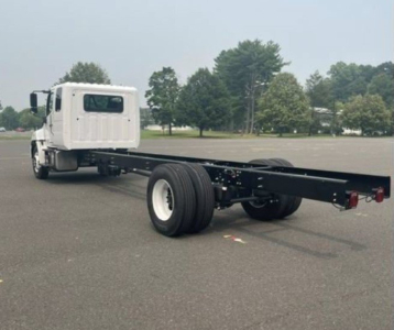 Cab chassis truck with long flatbed frame showing rear dual rear wheels and white cab, Hino L6 chassis truck configuration.