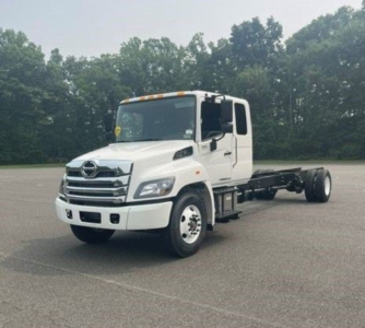 Hino L6 cab chassis truck front-left view showing white cab and chassis with two-axle rear setup and grill details.