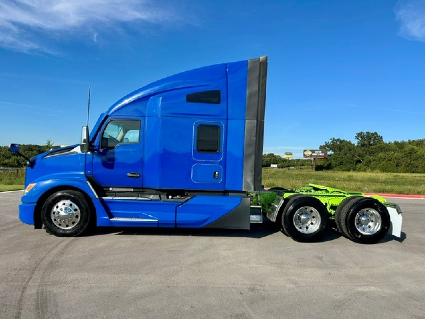 Kenworth T680 tractor in blue cab side view with sleeper, showing chrome wheels and dual rear axles", and text would include no other readable labels.