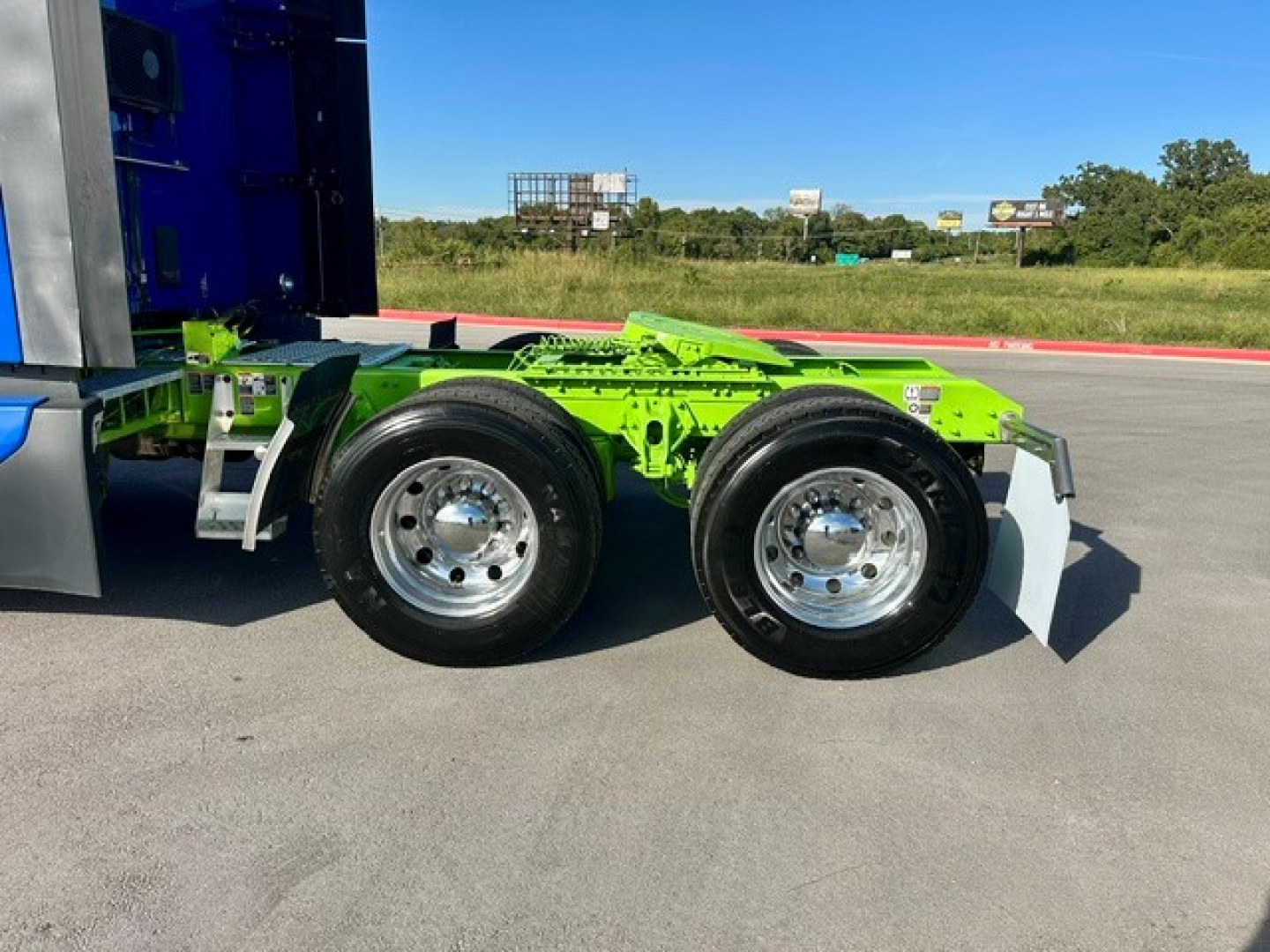 Kenworth T680 chassis with bright green frame and dual rear axles showing chrome wheels; no engine text visible.