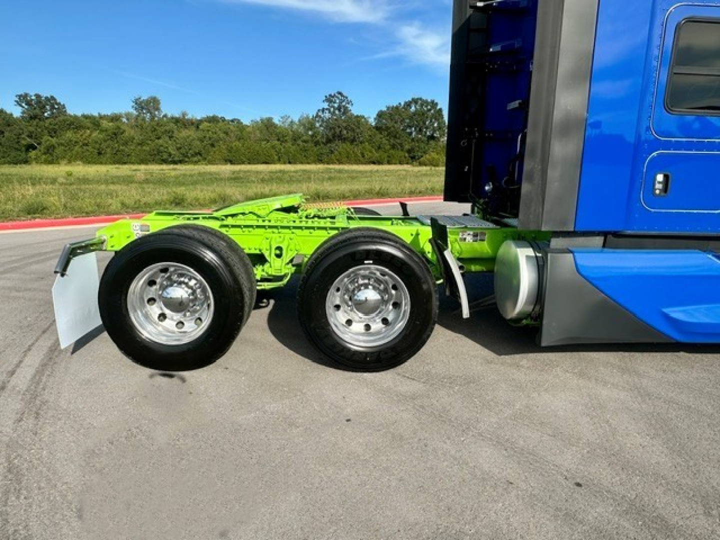 Kenworth T680 tractor rear showing dual rear axles and green chassis frame