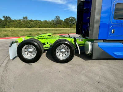 Kenworth T680 tractor rear showing dual rear axles and green chassis frame