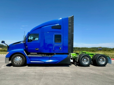 Kenworth T680 conventional sleeper tractor in blue, side profile view showing cab and rear wheels.