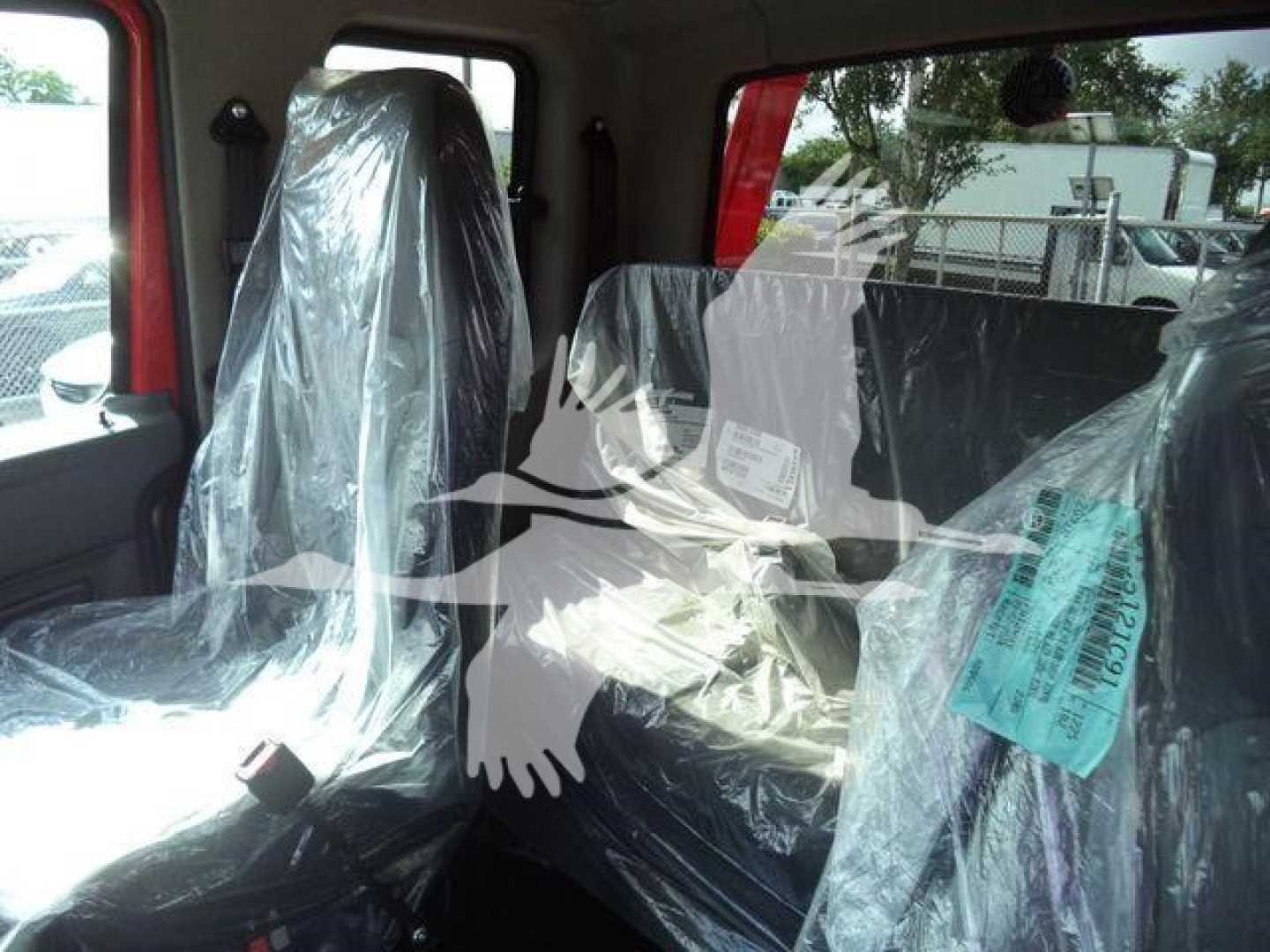 Cab interior of a 2025 International MV truck with seats wrapped in protective plastic.