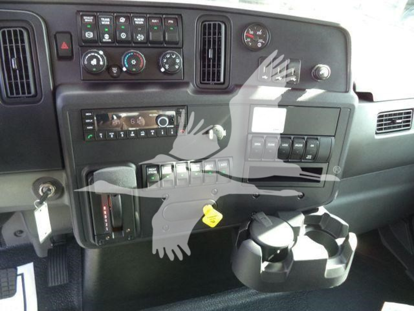 Dashboard interior of a 2025 International MV truck showing instrument panel, climate controls, switches, and cup holder.