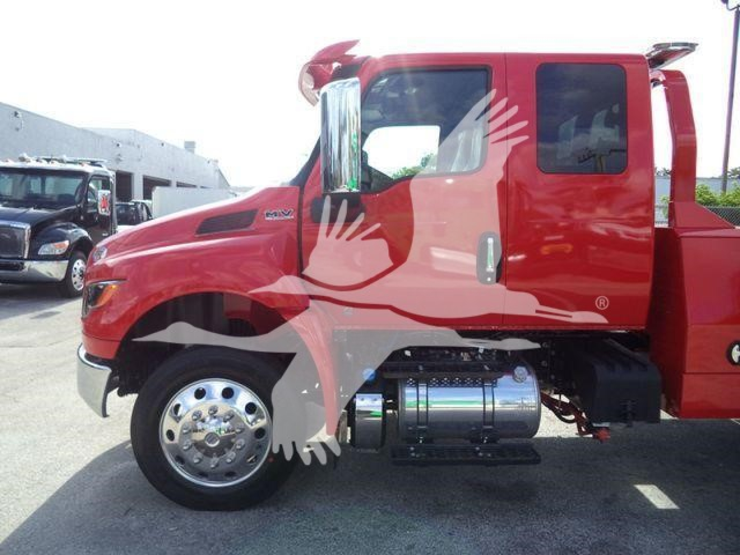 Truck cab side view showing International MV Series with chrome fuel tank and red paint