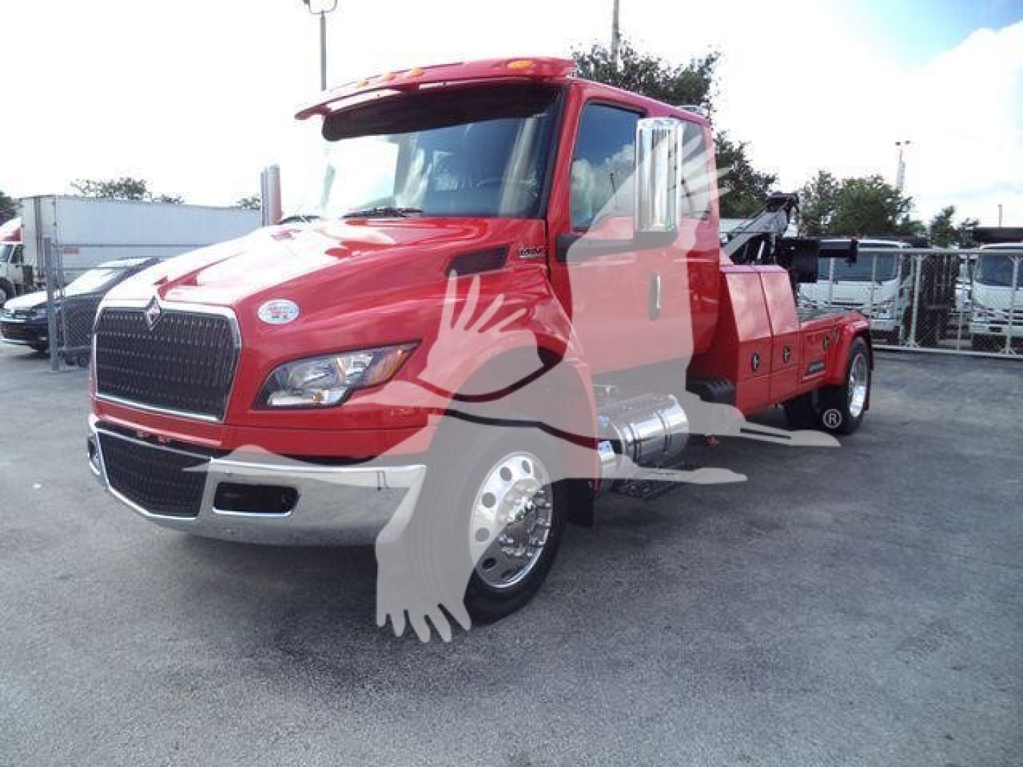 International MV truck in red with a winch-equipped bed and extended cab, front grille visible.