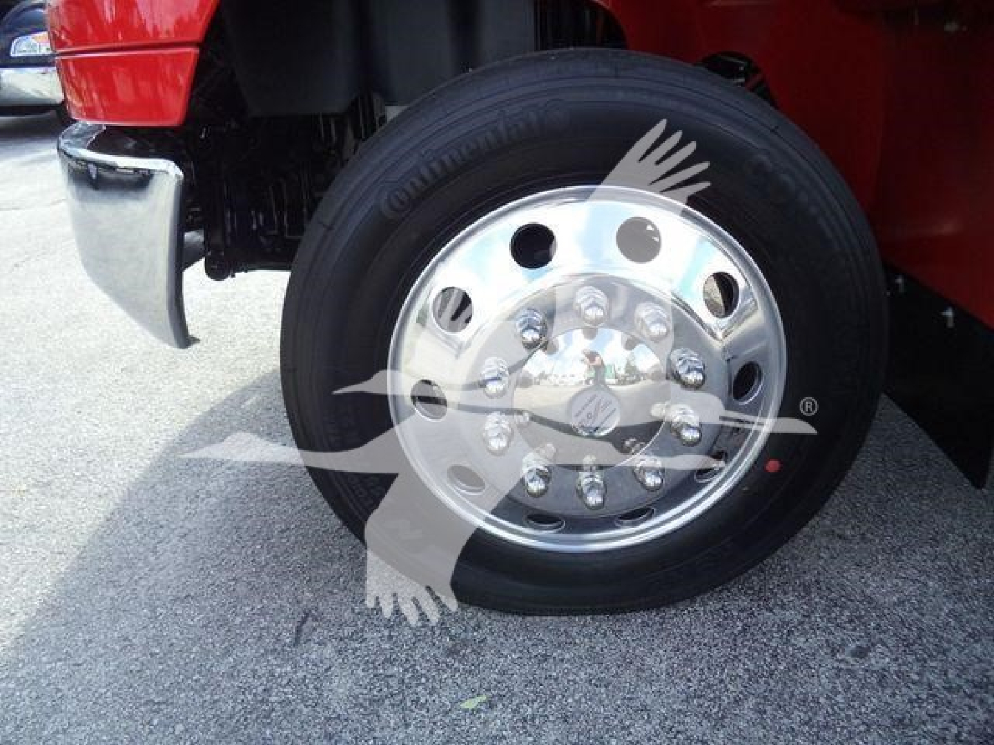 Wheel and chrome hub of a heavy-duty truck with lug nuts and tire tread visible