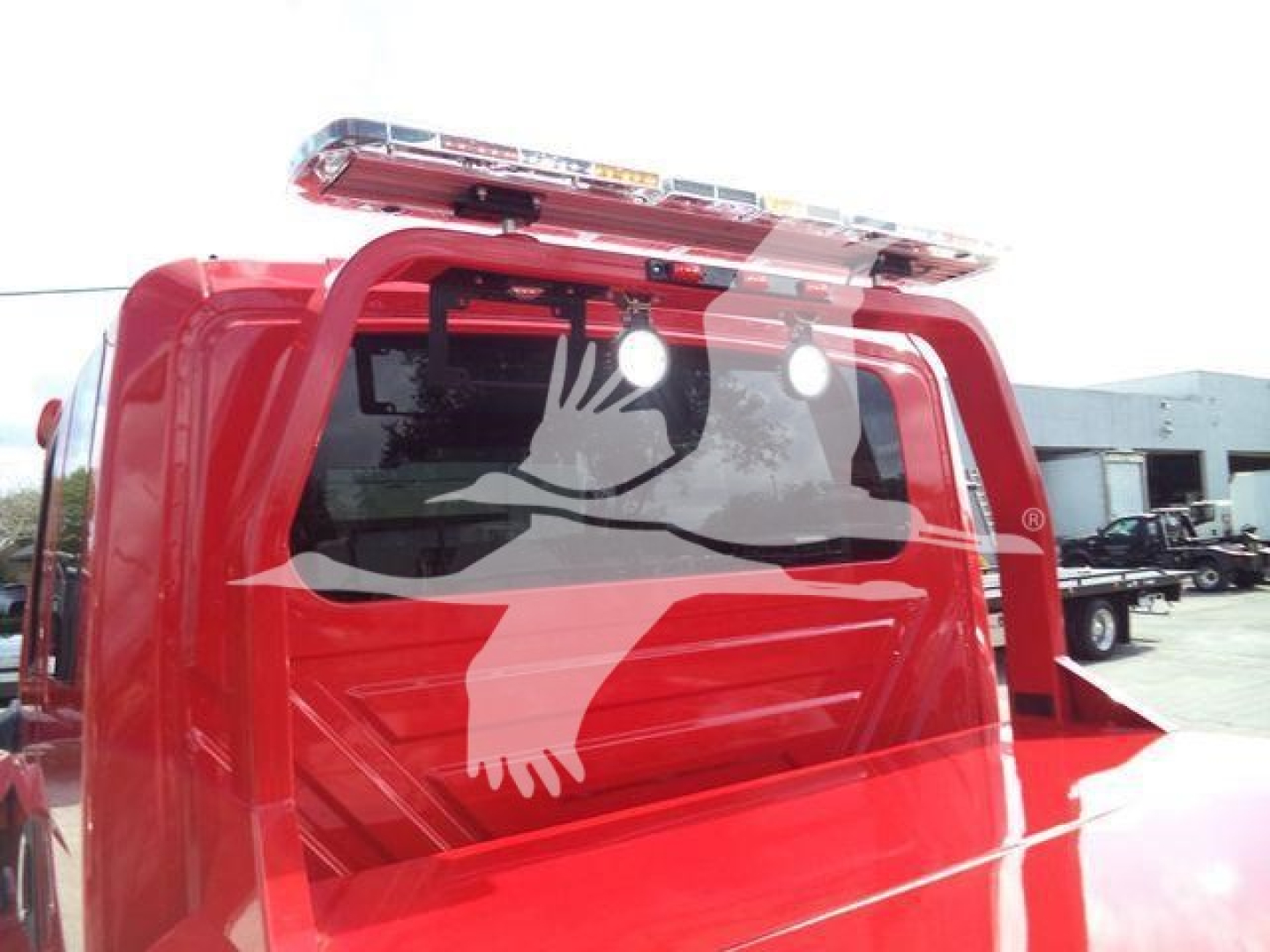 Winch-equipped 2025 International MV truck cab showing rear window and rooftop light bar.