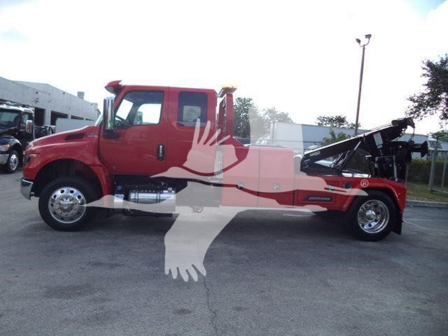 2025 International MV winch truck side view showing tow winch equipment and cab with red exterior and black towing bed.