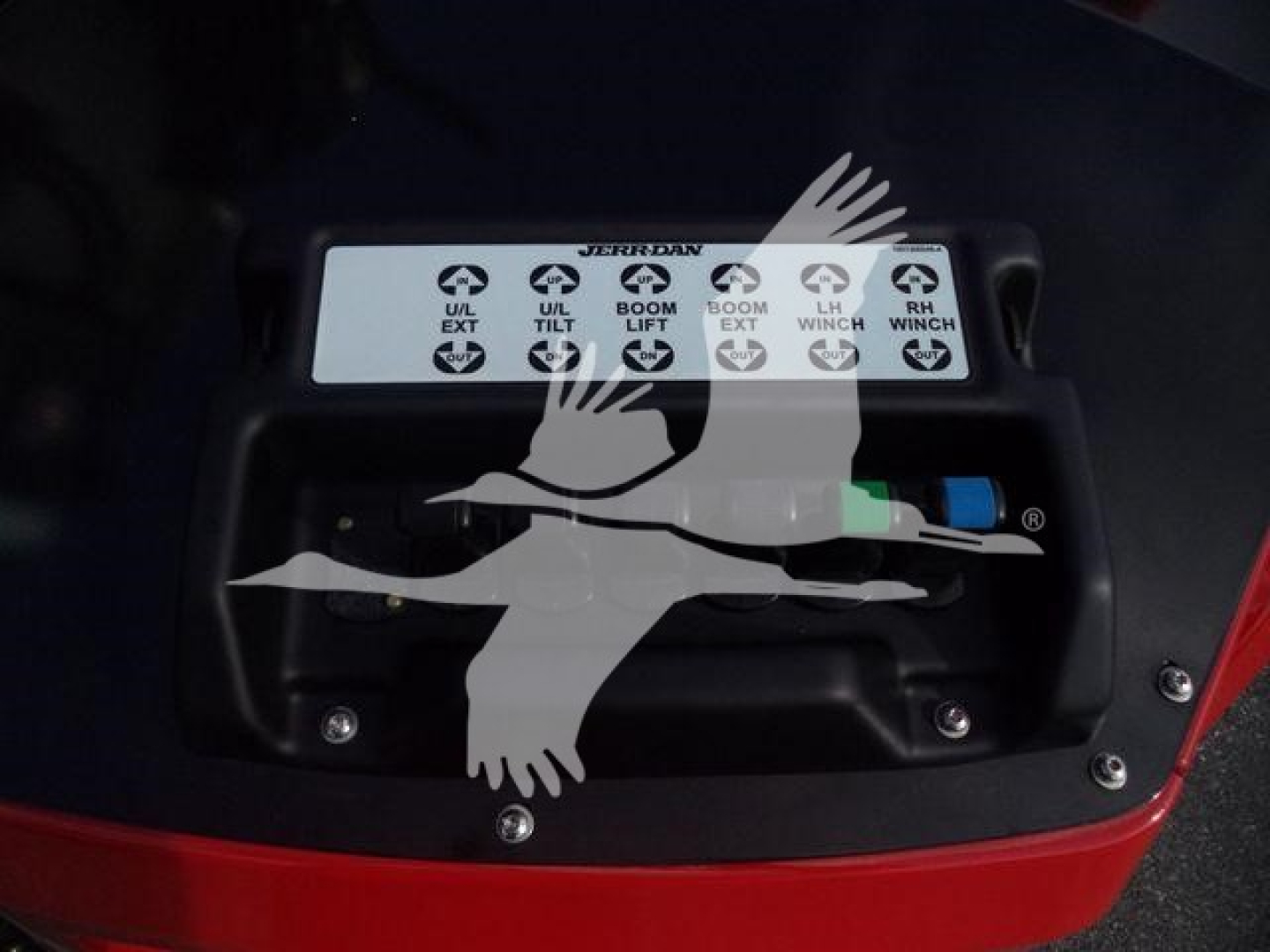 Winch control panel on a new 2025 International MV truck showing labeled high-level controls for U/D ext, tilt, boom lift, BOOM EXT, and RH/LH WND? with color-coded connectors, installed in red fender area.