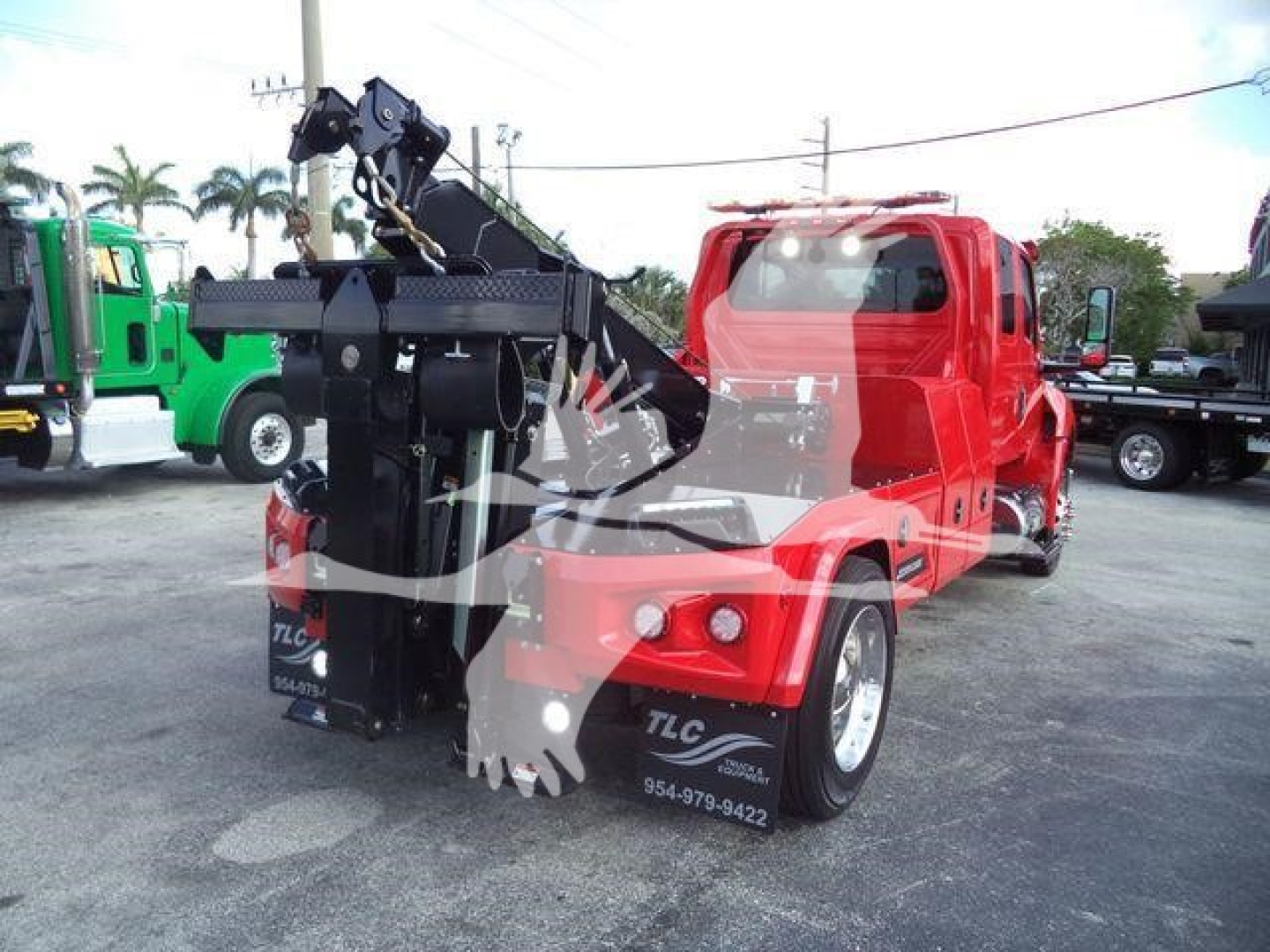 Winch-equipped red truck chassis showing heavy-duty crane and hook assembly at front, with TLC logo and contact numbers on the side.