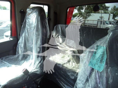 Cab interior of a 2025 International MV truck with seats wrapped in protective plastic.