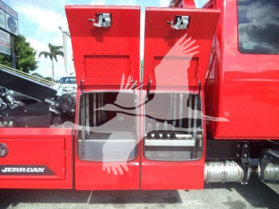 Front side of a red International MV truck with two open rear storage compartments and a visible engine bay area.