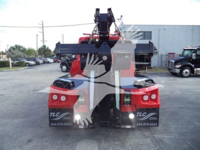 Rear view of a 2025 International MV winch truck showing tow hook assembly and lighting, with stock markings MPL60MVEXCABRED.