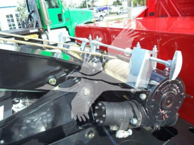 Winch system on a new 2025 International MV truck showing mechanical winch drum and cable assembly with motor housing and mounting brackets.