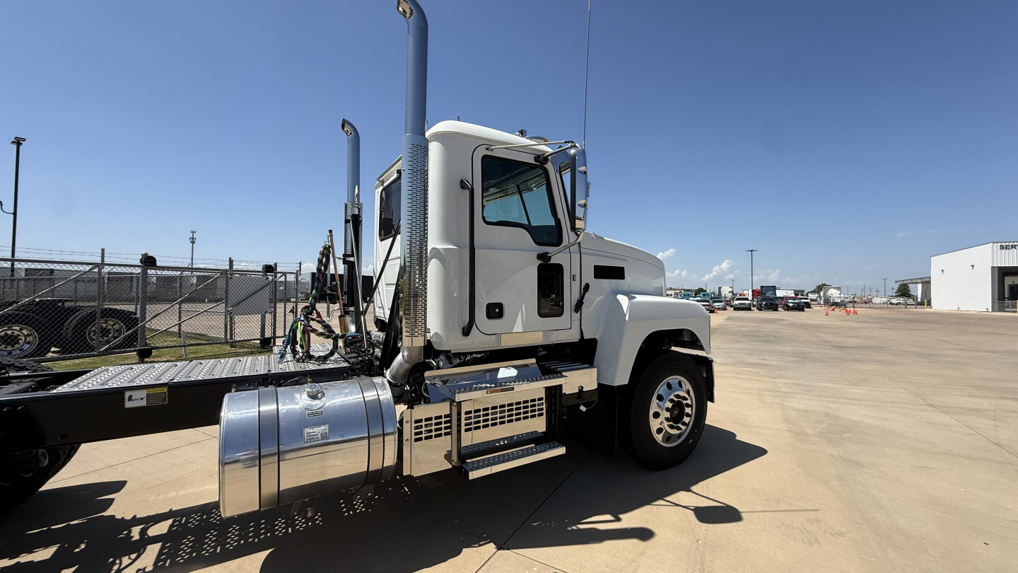 Truck cab side view showing fuel tank and steps on Mack PI64T conventional daycab.