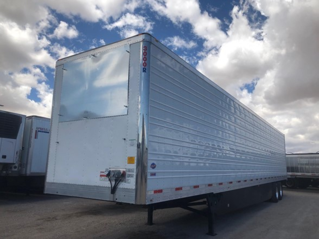 Trailer side view of a 2026 Utility Utility 3000R refrigerated trailer showing exterior aluminum cargo box and landing gear with blue sky and clouds.
