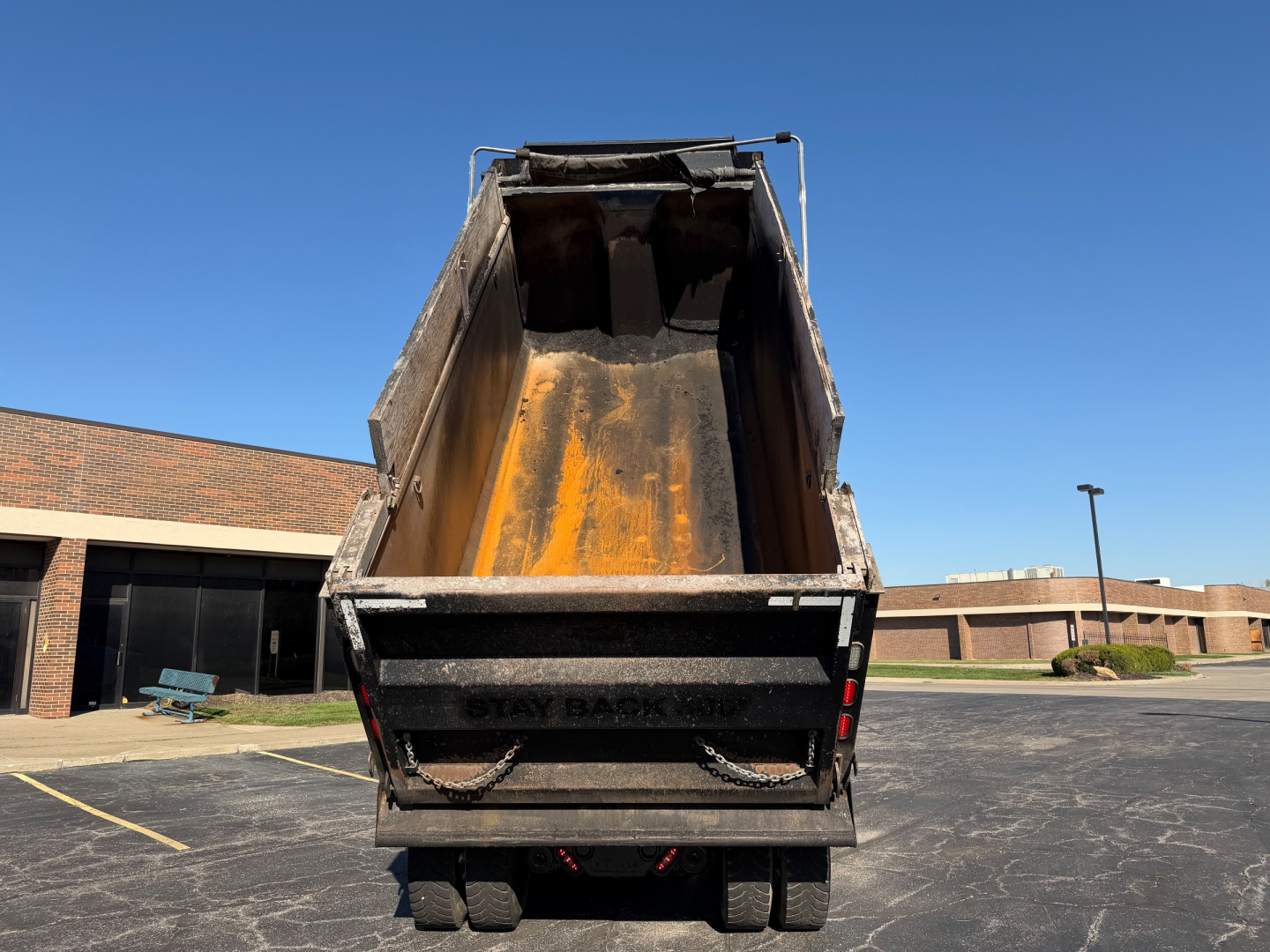 Dump truck dump bed of a 2023 Peterbilt 567 from rear view showing orange bed interior.