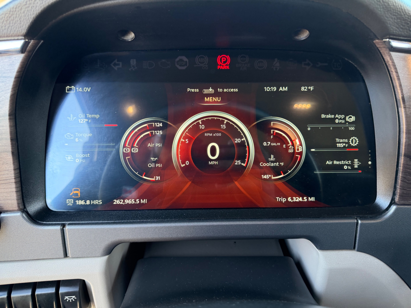 Peterbilt 567 interior digital dashboard display showing speedometer at 0 mph and various gauges in red theme.