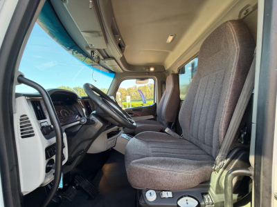 Peterbilt truck cab interior showing driver and passenger seats, steering wheel, dashboard, gear shifter. Visible text includes none.