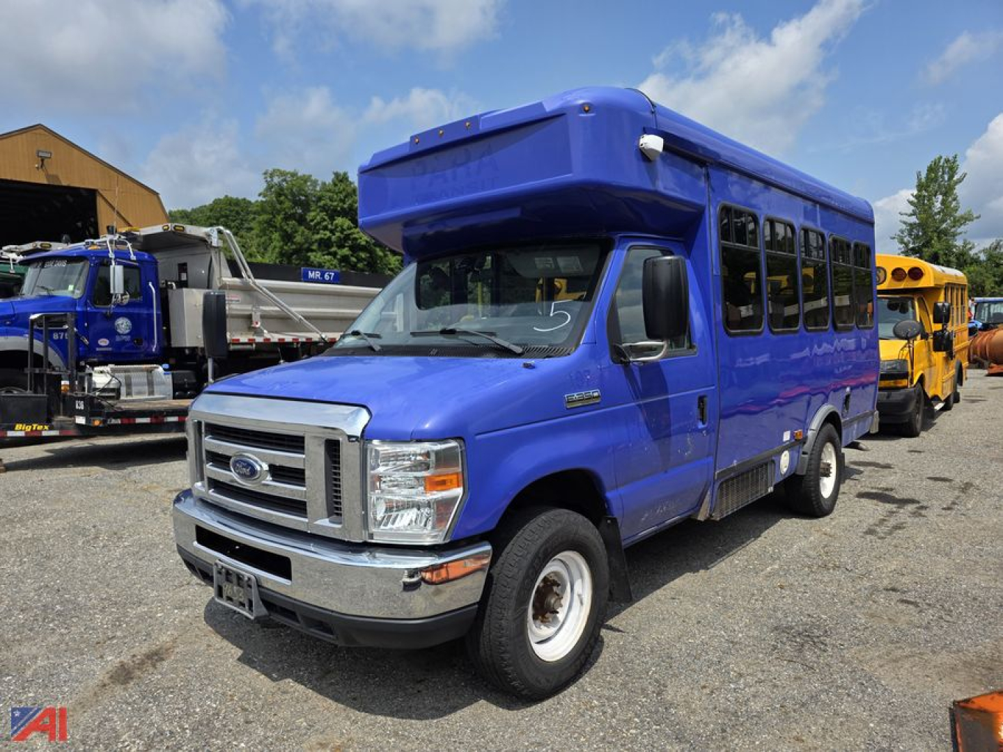 Ford E-Series passenger bus blue exterior, front-left view, with raised roof and large side windows. Ford emblem on grille, headlights, bumper, and wheel wells visible.