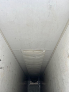 Trailer interior showing refrigerated cargo space of a 2014 Wabash reefer with white walls and ceiling, vertical side panels, and a center aisle.
