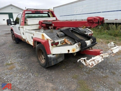 Tow truck with a red boom and white flatbed, rear equipment visible, used condition.