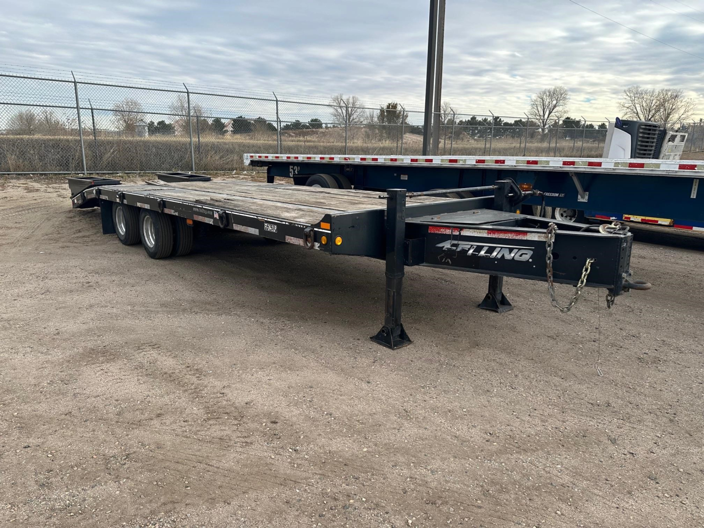 Felling Ft-24-2 LP flatbed trailer showing steel frame and dual rear axles with landing gear and chains.
