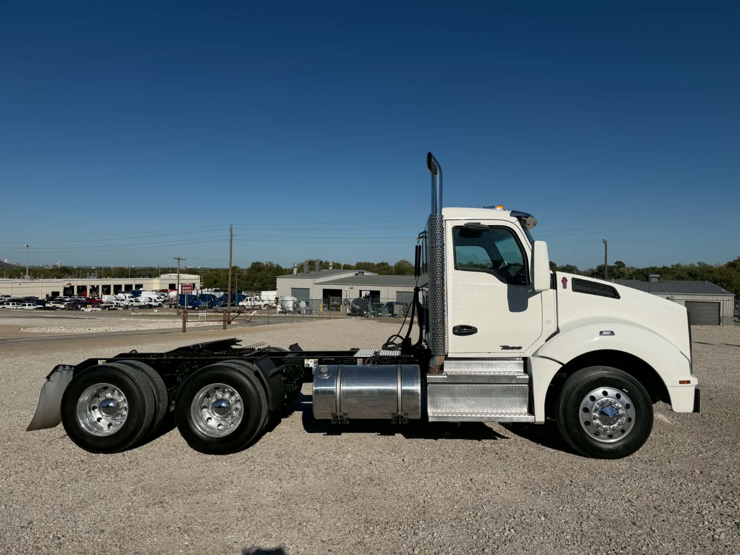 Kenworth T880 daycab tractor in side view showing chassis and cab with dual rear axles and fuel tanks.