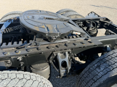 Truck chassis of a used 2022 Kenworth T880, showing the fifth-wheel mount and rear frame with spare tire carrier and wiring harness.