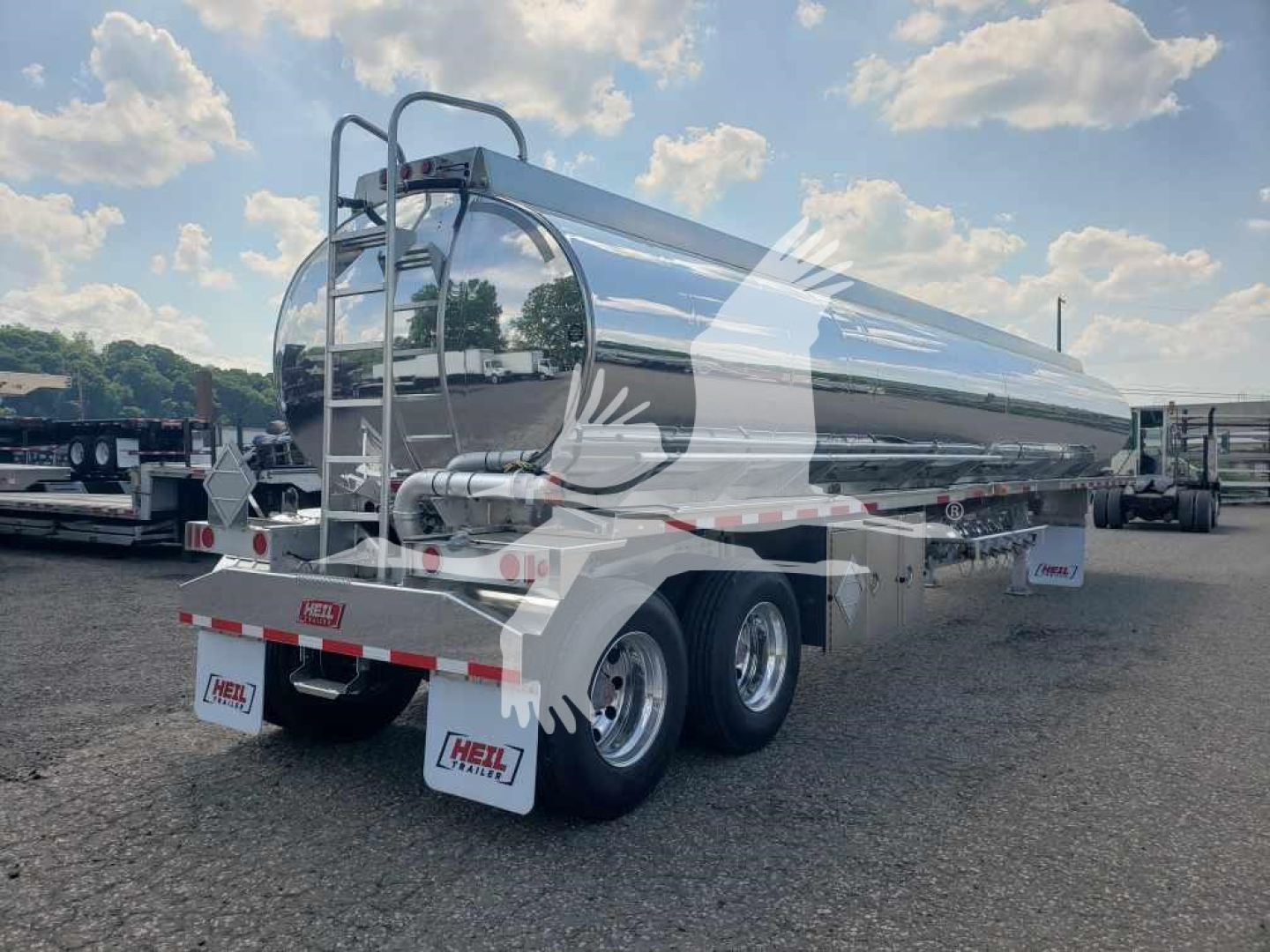 Heil 406A Petro tanker trailer rear three-quarter view showing dual rear axles, polished aluminum tank, rear steps, safety rails, and HEIL branding on mud flaps.