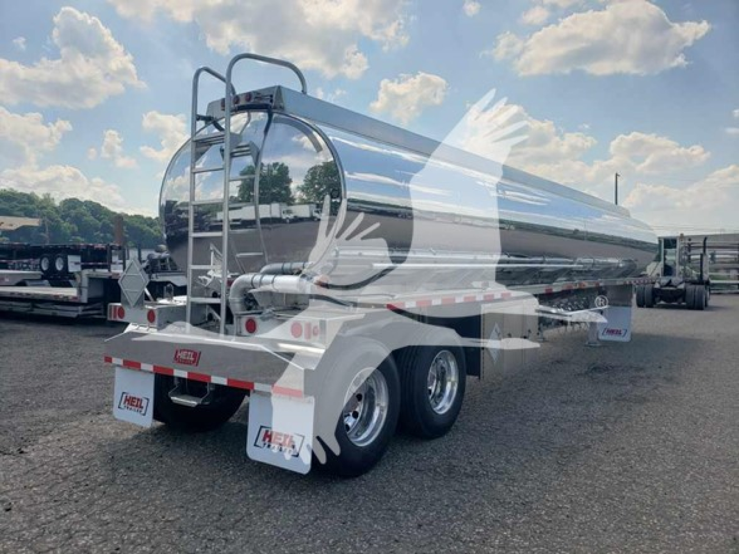 Heil 406A Petro fuel trailer with polished aluminum cylindrical tank, rear view showing tandem axle, mud flaps, and rear ladder.