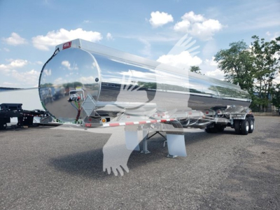 Heil 406A Petro trailer showing polished aluminum cylindrical tanker on a dual-axle trailer with support legs and rear reflective striping.