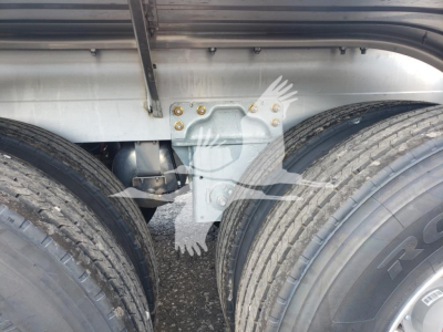 Trailer chassis and dual rear axles of a Heil 406A Petro, showing part of frame, mounting brackets, and tires.