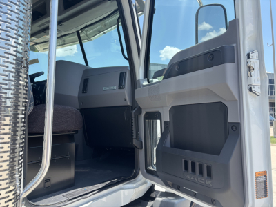 Mack GR64B truck cab interior door area showing dashboard and door storage with Mack logo, gray and black panels.