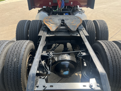 Kenworth T680 chassis view showing rear dual axles and fifth wheel mount with drivetrain components visible.