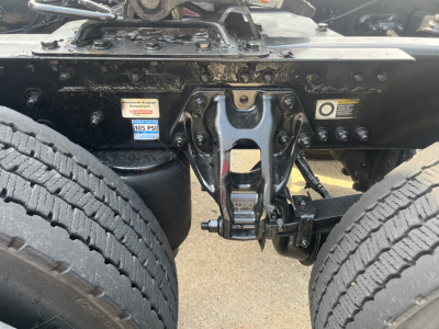 Kenworth T680 chassis showing undercarriage with fifth wheel, air suspension bags, and dual rear tires; visible labels include 105 PSI air pressure sticker.