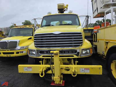 Front view of a yellow 2004 Sterling LT8500 National Crane truck with a front-mounted hydraulic plow/boom. Visible text includes 'STERLING' on grille and warning decals on plow.