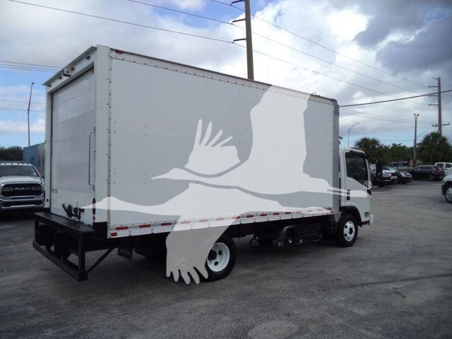 Isuzu NPR HD box truck viewed from rear-left side showing cargo box and rear bumper. Visible text not legible.