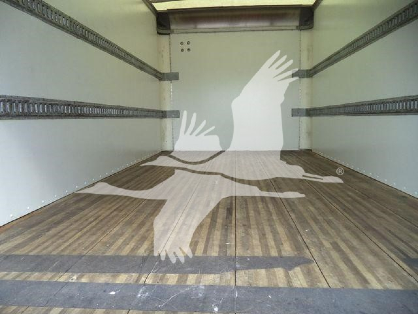Isuzu NPR-HD box truck cargo area with wooden floor and side rails, empty interior.