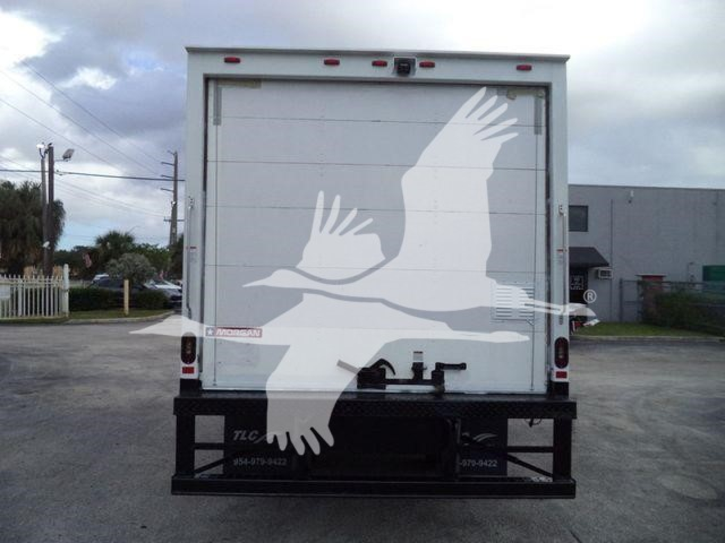 Isuzu NPR HD box truck rear showing large white graphic on back doors and bumper, stock number T11138FM.