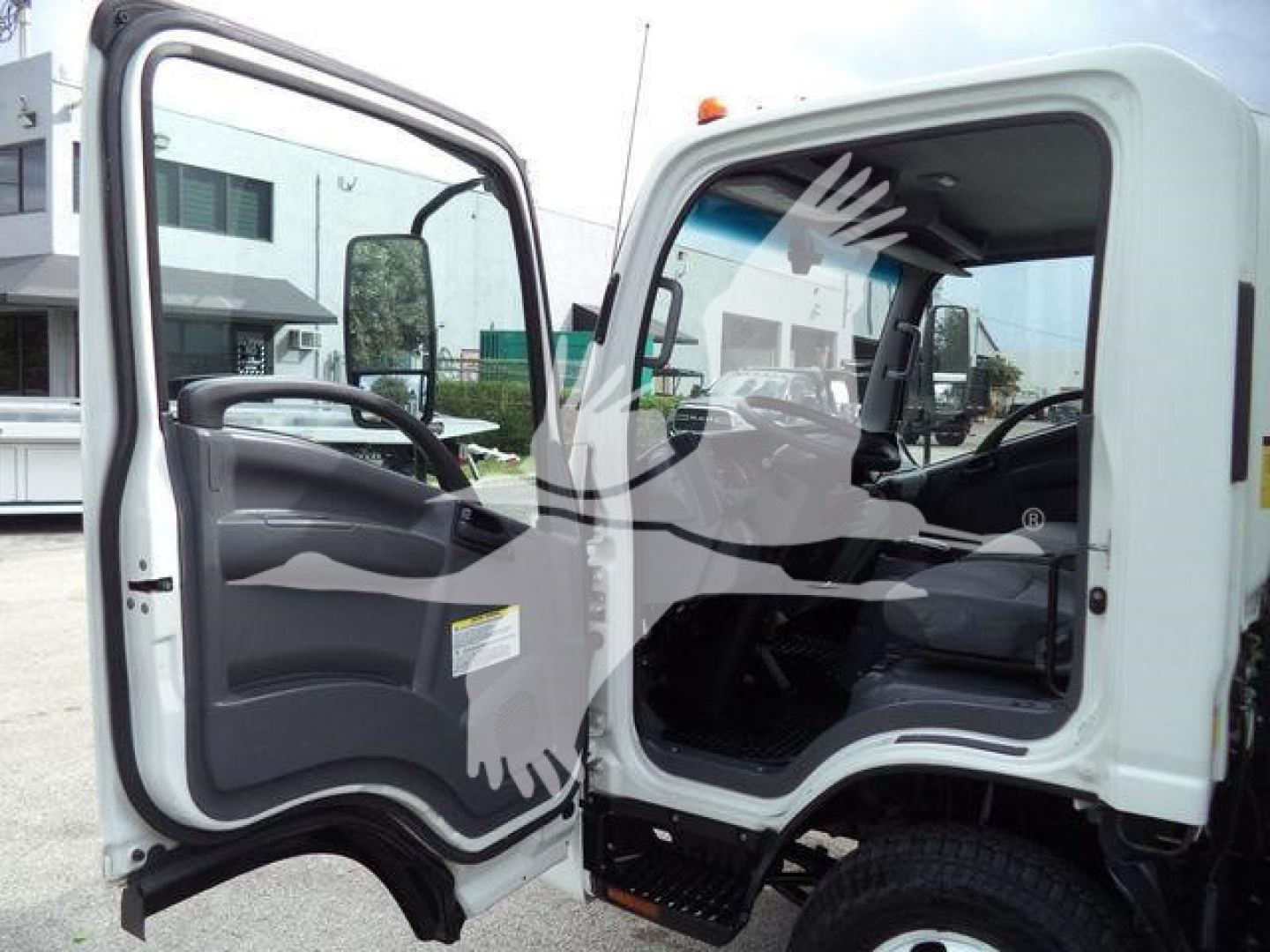 Isuzu NPR HD cab interior and open door showing driver's seat and dashboard in a white box truck