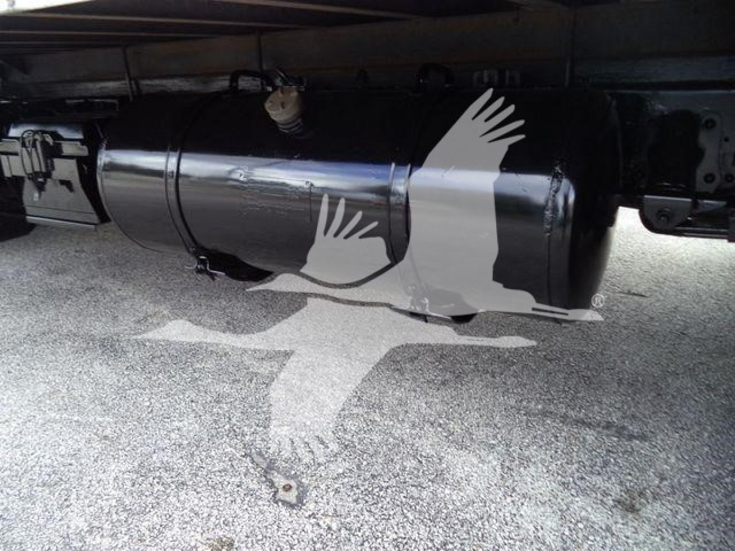 Isuzu NPR-HD truck fuel tank under chassis with metal cylindrical tank and mounting brackets visible.