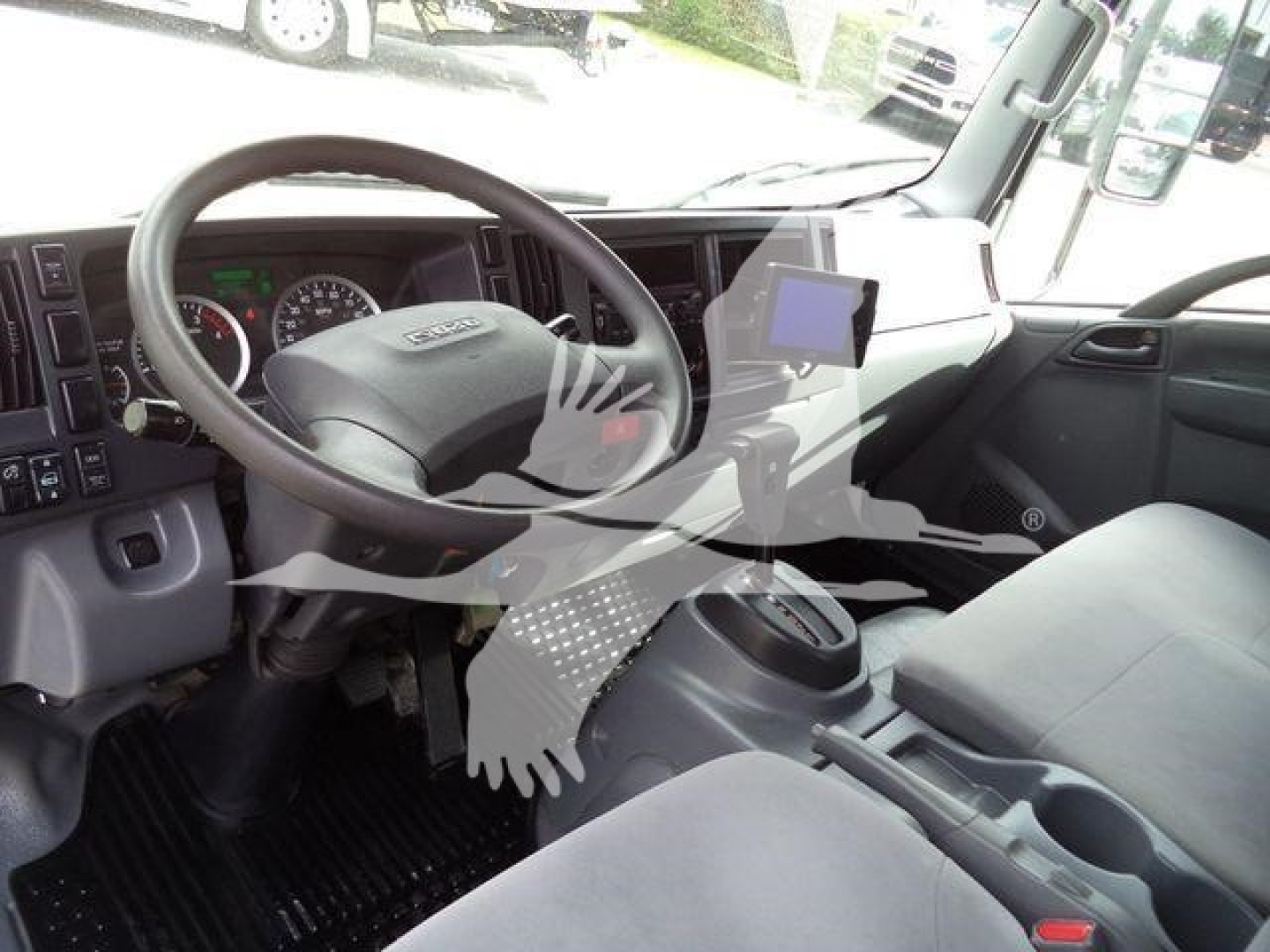 Isuzu NPR HD truck interior showing steering wheel, dashboard, and center console with mounted tablet device.