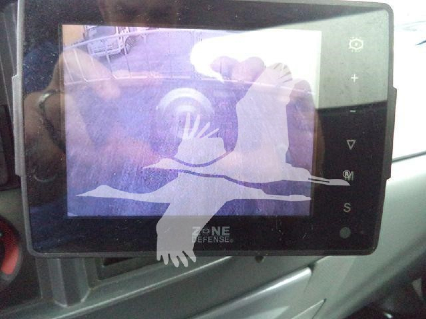 Isuzu NPR HD dashboard/console with Zone Defense monitor showing a reflection on the screen.