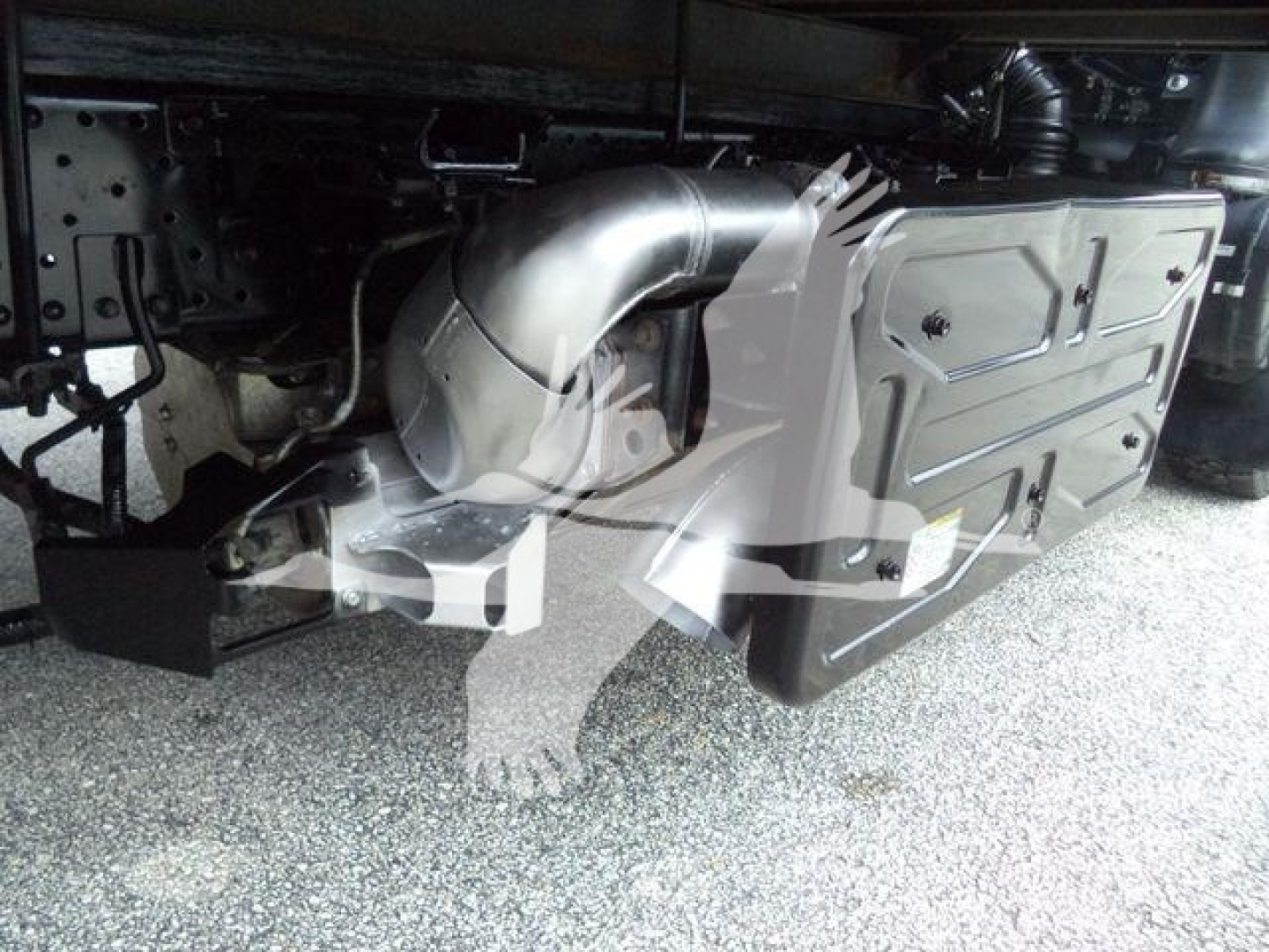 Isuzu NPR-HD truck undercarriage showing exhaust/muffler pipe and side panel near the frame rail.