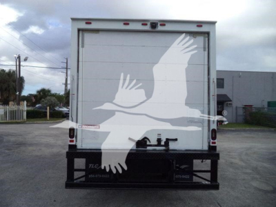 Isuzu NPR HD box truck rear showing large white graphic on back doors and bumper, stock number T11138FM.